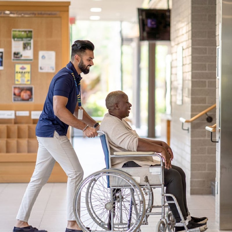 wheeling a person from a health facility to a medical WC vehicle
